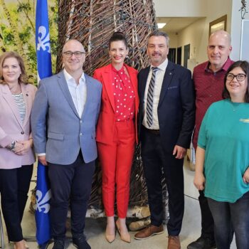 de gauche a droite François Jacques, député de Mégantic, devant lui Paul Lupien directeur général de la COPHAN qui est en fauteuil roulant, Geneviève Hébert, Députée de Saint-François, Stéphane Thériault directeur général CQEA, Mme Geneviève Guil;bault Vice-première ministre · Ministre des Transports et de la Mobilité durable., M. Sébastien Schneeberger Député de Drummond–Bois-Francs adjoint parlementaire au transport et président du comité pour le transport adapté, Steve Breton directeur général de Defi Polytech et devant lui une employée de Défi Polytech